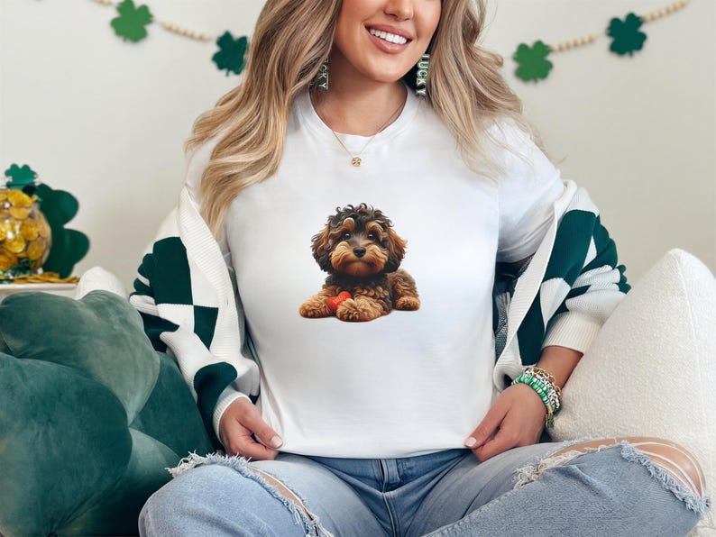 A woman wearing a white t-shirt with a dog image is sitting on a couch, smiling.