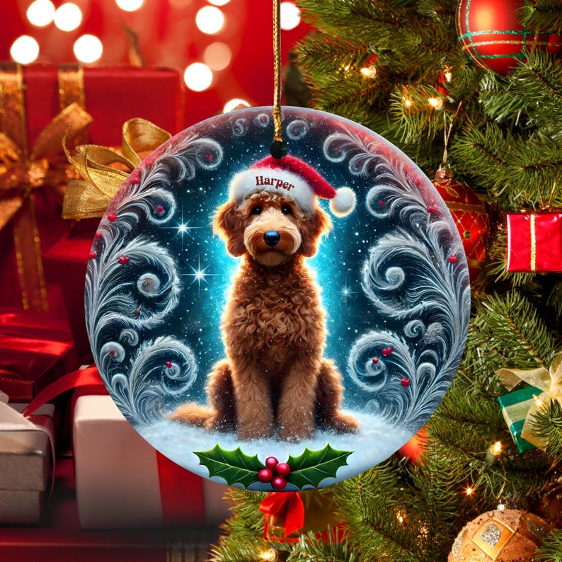 A cozy Christmas ornament featuring a goldendoodle sitting in fluffy snow while wearing a Santa hat with the name “Harper.” Frosty feather-style swirls, glittering stars, and holly berries add decorative flair. The glowing background lights create warmth and charm, making it ideal as a personalized gift or tree decoration.