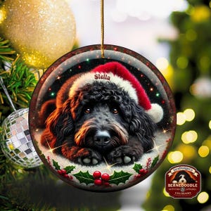 Black bernedoodle or labradoodle dog ceramic ornament show hanging with a gold string.  The ornament measures 3 inches in diameter and is a full gloss, printed on both sides.