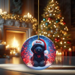 Capture the magic of the season with this adorable black Goldendoodle puppy wearing a festive Santa hat, surrounded by glowing red berries and twinkling snowflakes! Perfect personalized Christmas tree ornament for doodle parents. Add your dog's name (like "Stella") for a heartfelt touch. High-quality ceramic, vibrant print, gold string included. Ideal dog mom/dad gift, stocking stuffer, or memorial keepsake. Handmade holiday charm!