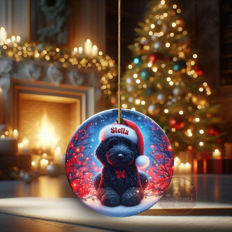 Capture the magic of the season with this adorable black Goldendoodle puppy wearing a festive Santa hat, surrounded by glowing red berries and twinkling snowflakes! Perfect personalized Christmas tree ornament for doodle parents. Add your dog's name (like "Stella") for a heartfelt touch. High-quality ceramic, vibrant print, gold string included. Ideal dog mom/dad gift, stocking stuffer, or memorial keepsake. Handmade holiday charm!