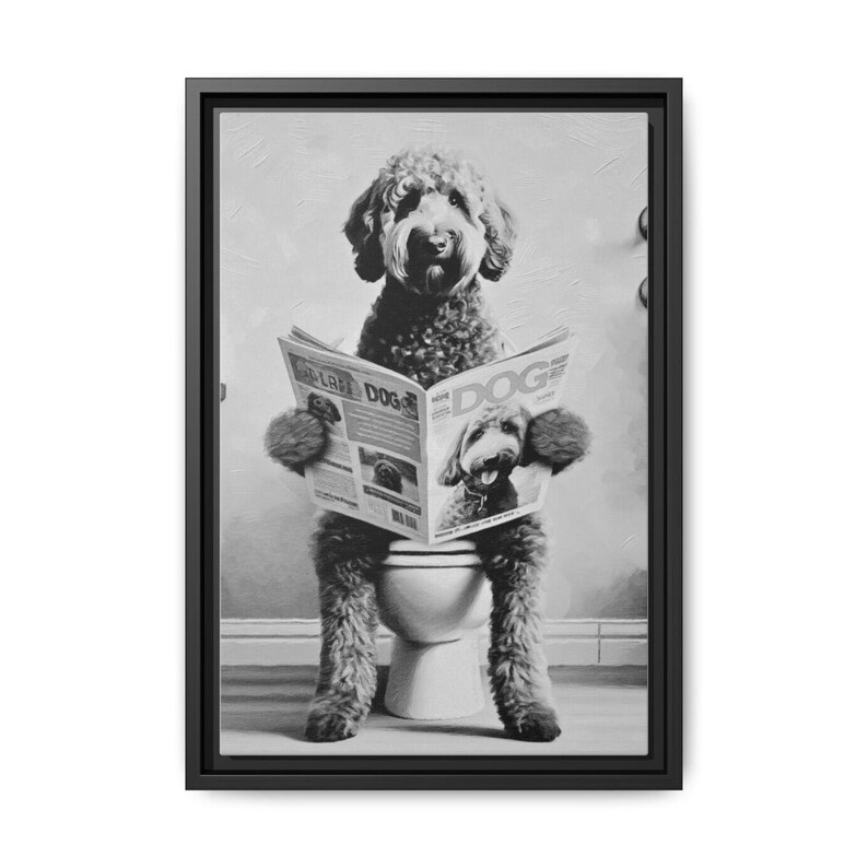 May include: A black and white framed wall art print depicting a curly-haired dog sitting on a toilet while reading a newspaper titled DOG. The dog is shown from the front, holding the open newspaper with both front paws, in a humorous scene.