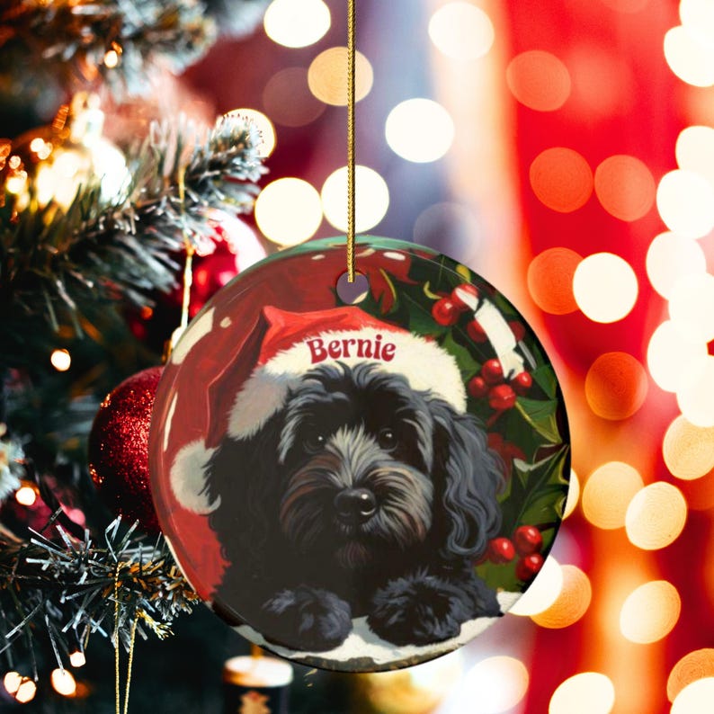 A black bernedoodle dog wearing a santa hat that is personalized with their name on it in this adorable Ceramic ornament!  Design appears on the front and the back of this doodle dog ornament!