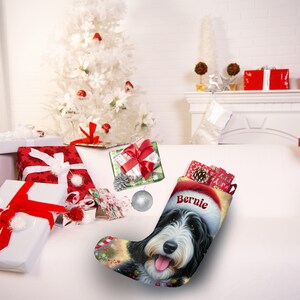 Op de afbeelding: Kerstsok met een hondenportret met een kerstmuts, met de naam "Bernie" op de muts. De sok is gevuld met kleine cadeautjes, omringd door ingepakte cadeaus en een versierde kerstboom.