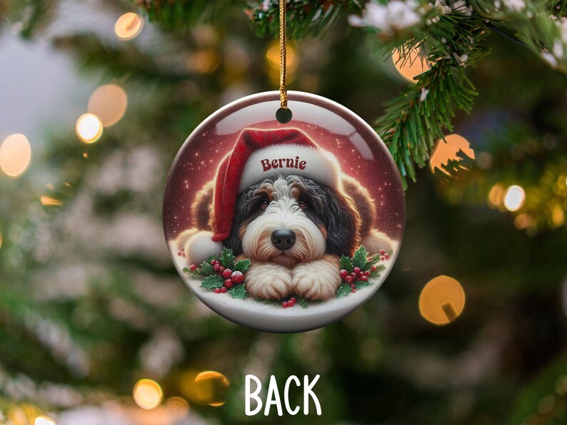 Personalize your holiday decor with this charming Bernedoodle Christmas ornament! Featuring a cute Bernedoodle in a festive Santa hat and customizable name, this round ornament adds warmth and joy to any tree. Perfect for dog lovers and unique gifts!
