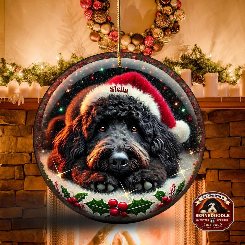 Black bernedoodle or labradoodle dog ceramic ornament show hanging with a gold string.  The ornament measures 3 inches in diameter and is a full gloss, printed on both sides.