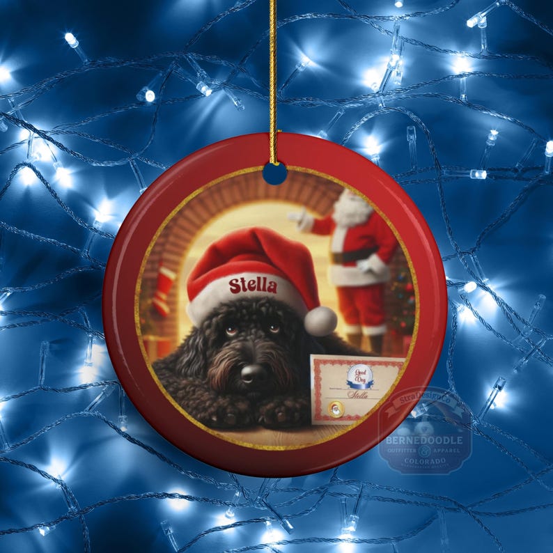 This ceramic ornament features a cute black goldendoodle (or Labradoodle)...Or black bernedoodle dog wearing a Santa hat and being on their best behavior for Santa, surrounded by holiday decorations.  Three inch ceramic dog ornament with a black bernedoodle black golden doodle black goldendoodle dog wearing a santa hat on this cute dog ornament gift.  Perfect ornament for a dog person, dog lover, doodle mom or doodle dad.