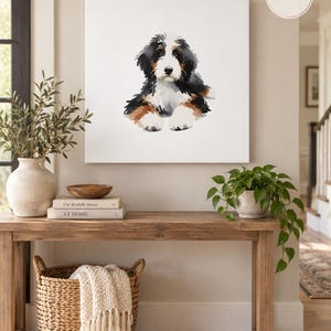 Puede incluir: Un lienzo cuadrado de arte mural que presenta una ilustraci&oacute;n en acuarela de un cachorro de boyero de Berna con pelaje negro, blanco y marr&oacute;n. La obra de arte est&aacute; etiquetada con las dimensiones 32x32 pulgadas en la esquina superior derecha.