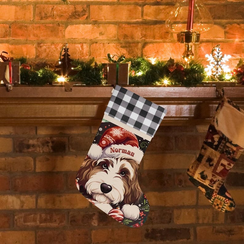 A festive Christmas stocking featuring a whimsical illustrated doodle dog wearing a red Santa hat, surrounded by holiday ornaments and greenery in a warm, detailed Christmas art style. The top of the stocking has a classic red and black buffalo-plaid cuff, and the stocking hangs from a white mantel decorated with evergreen garland and gold ornaments. The stocking design is personalized with your dog’s name, making it a charming and custom holiday décor piece for dog lovers.