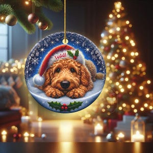 Golden Doodle dog ceramic ornament show hanging with a gold string.  The Goldendoodle Dog ornament measures 3 inches in diameter and is a full gloss, printed on both sides.
