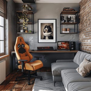May include: An orange and black gaming chair is the focal point of a home office. A framed portrait of a dog wearing a crown and ruff hangs above a desk with a keyboard and laptop. Shelves display decor, and a gray sofa completes the room.