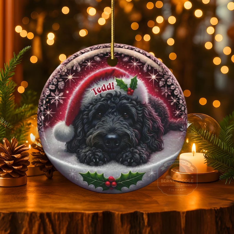 Black bernedoodle or labradoodle dog ceramic ornament show hanging with a gold string.  The ornament measures 3 inches in diameter and is a full gloss, printed on both sides.