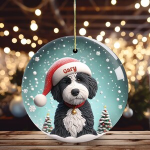 Celebrate the holidays with this adorable Bernedoodle Christmas ornament! Featuring a charming claymation-style Bernie in a Santa hat, surrounded by snowflakes and festive trees, this ornament adds warmth and joy to any holiday decor. For dog lovers!