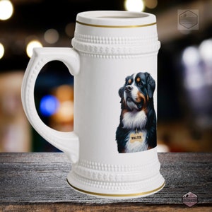May include: White ceramic beer stein with a handle and gold trim. The stein features a detailed illustration of a Bernese Mountain Dog with a tag that says "WALTER". The stein has a decorative design around the top and bottom.