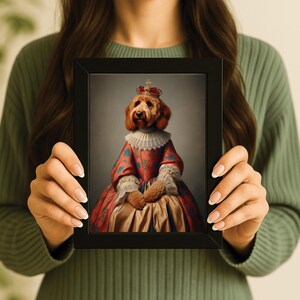 May include: A framed portrait of a dog dressed in regal attire. The dog, with golden fur, wears a red and gold dress, a ruffled collar, and a crown. The portrait is held by a person wearing a green sweater.