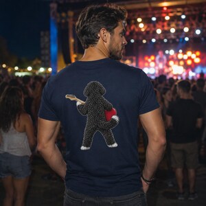 May include: A navy blue t-shirt featuring a graphic on the back of a curly-haired black dog standing on its hind legs, holding a light-colored electric guitar and a bright red heart shape against its side, with white accents on its paws.