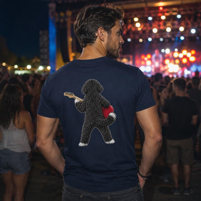 May include: A navy blue t-shirt featuring a graphic on the back of a curly-haired black dog standing on its hind legs, holding a light-colored electric guitar and a bright red heart shape against its side, with white accents on its paws.