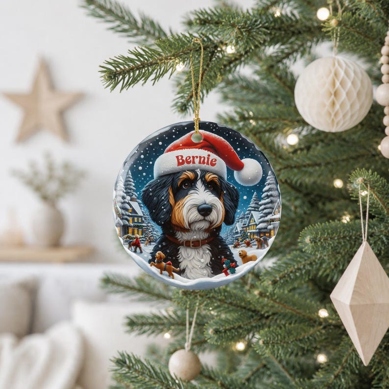 A Christmas tree decorated with ornaments, including a large ornament featuring a Bernese mountain dog wearing a Santa hat and the name " Bernie" written on it.