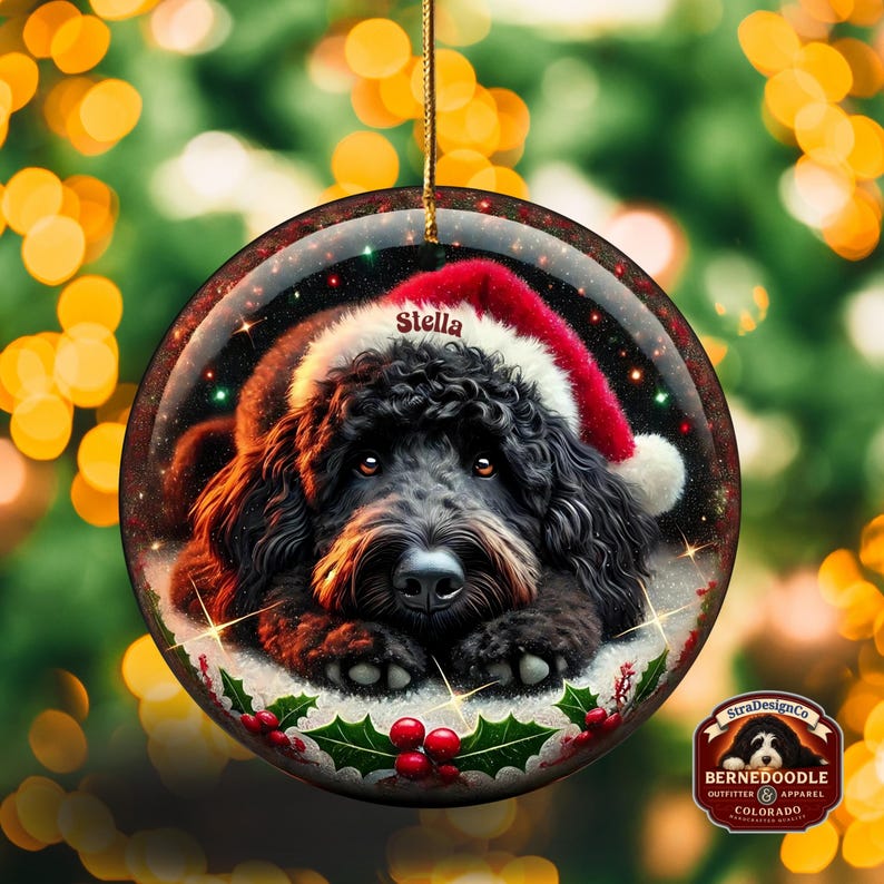 Black bernedoodle or labradoodle dog ceramic ornament show hanging with a gold string.  The ornament measures 3 inches in diameter and is a full gloss, printed on both sides.