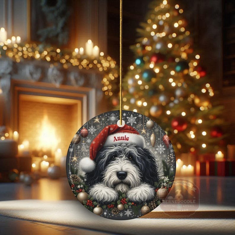 Sheepadoodle custom ornament on display with glowing lights in the background.  This 3 inch ceramic ornament is perfect for Sheepa Doodle lovers everywhere.
