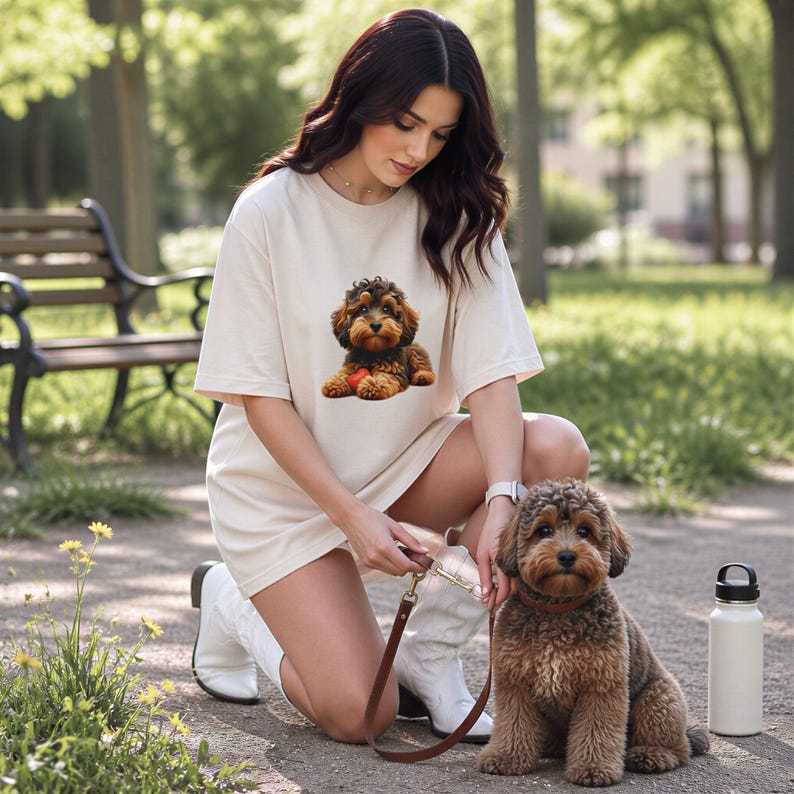 A woman kneeling down next to a small dog in a park, with a water bottle nearby.