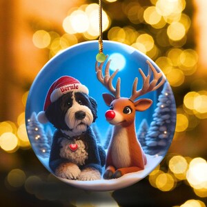 A fluffy Bernedoodle sits beside a gentle reindeer with a glowing red nose in a snowy winter forest. Soft blue and golden holiday lighting highlights the animals as snow falls around them. The Bernedoodle’s expressive face and the reindeer’s warm glow create a peaceful, magical Christmas scene perfect for woodland and dog-themed holiday décor.