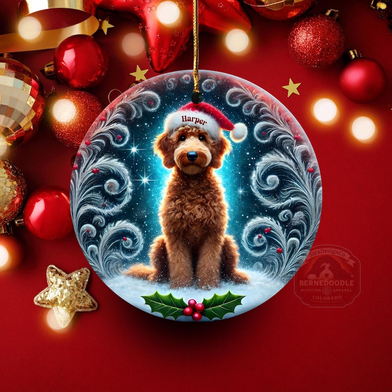 Beautiful round ornament featuring a sweet brown goldendoodle in a Santa hat with the name “Harper.” The background shows magical snowy sparkles and stylized frost swirls. Holly berry details sit at the bottom, while golden holiday lights glow warmly in the distance. Perfect gift for doodle lovers and custom Christmas tree decorations.