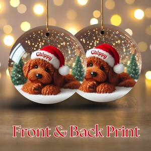 May include: Two round Christmas ornaments. Each features a brown dog wearing a Santa hat with the name "Chippy". The ornaments have a clear background with a snowy scene and small Christmas trees. The text "Front & Back Print" is at the bottom.
