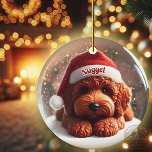 This ceramic ornament features a cute red mini-doodle golden doodle or goldendoodle dog wearing a Santa hat in a snow globe setting, surrounded by holiday decorations. Perfect for adding a festive touch to your Christmas tree or as a thoughtful gift for dog lovers.