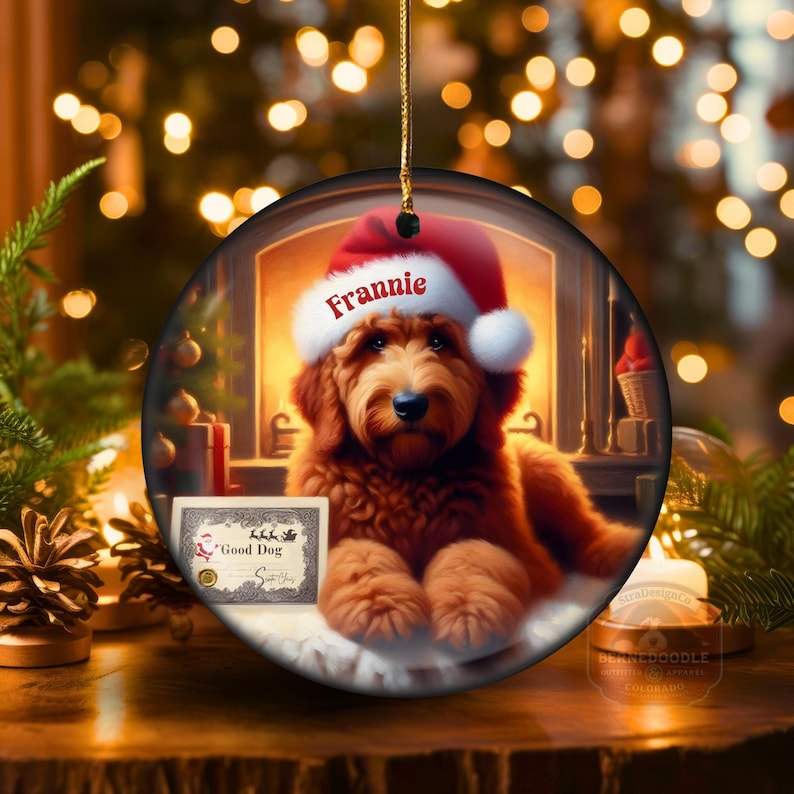 Goldendoodle Ornament - 3 inch round ceramic fully gloss Christmas Ornament hanging with a gold string against a warm background.