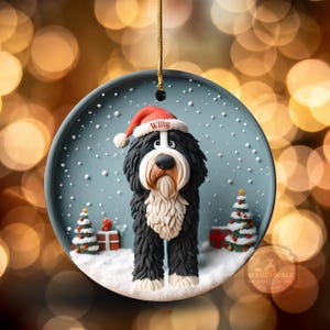 May include: A round Christmas ornament featuring a Bernedoodle dog wearing a Santa hat with the name "Willy". The dog is black and white with a cream-colored beard, standing in a snowy scene with Christmas trees and presents.