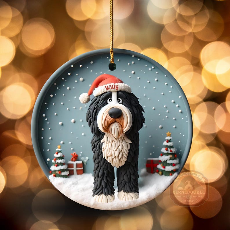 May include: A round Christmas ornament featuring a Bernedoodle dog wearing a Santa hat with the name "Willy". The dog is black and white with a cream-colored beard, standing in a snowy scene with Christmas trees and presents.