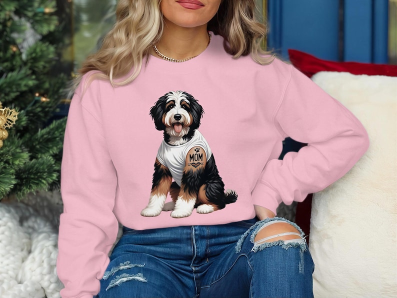 A woman wearing a pink sweatshirt with a graphic of a dog on it.