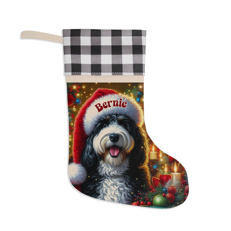 May include: Christmas stocking with a black and white dog wearing a Santa hat, the name "Bernie" is on the hat. The stocking has a buffalo check cuff and a festive holiday scene.
