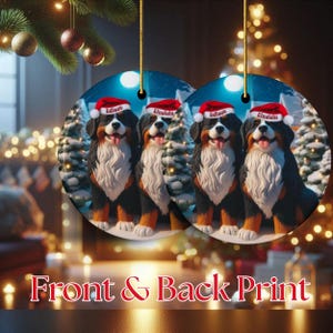 Op de afbeelding: Ronde kerstversieringen met een afbeelding van een Berner Sennenhond met een kerstmuts, met de namen "Edison" en "Einstein". De ornamenten hebben een besneeuwde bosachtergrond en de tekst "Front & Back Print".
