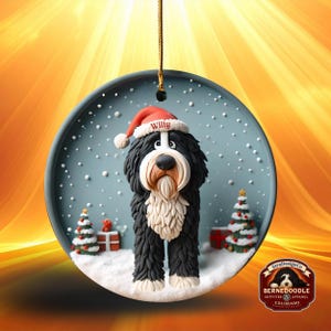 May include: A round Christmas ornament featuring a Bernedoodle dog wearing a Santa hat with the name "Willy". The dog is black, white, and brown, standing in a snowy scene with Christmas trees and presents. The ornament has a gold hanging string.
