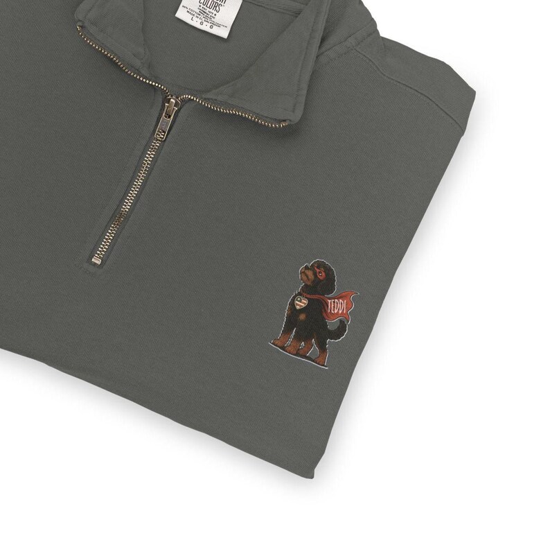 Pu&ograve; includere: Felpa grigio scuro con zip a un quarto e una piccola grafica ricamata di un cane nero con un mantello rosso con il nome "TEDDI". La felpa ha una vestibilit&agrave; rilassata e una sensazione morbida e confortevole.