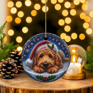Golden Doodle dog ceramic ornament show hanging with a gold string.  The Goldendoodle Dog ornament measures 3 inches in diameter and is a full gloss, printed on both sides.