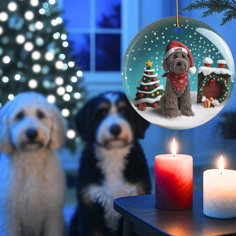 May include: A Christmas ornament featuring a brown dog wearing a Santa hat and red bandana, with a Christmas tree and a chimney. Two dogs and two lit candles are in the foreground, with a Christmas tree in the background.