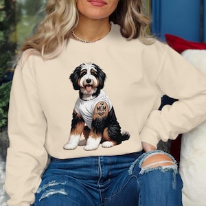 A woman wearing a white sweatshirt with a graphic of a dog on it.