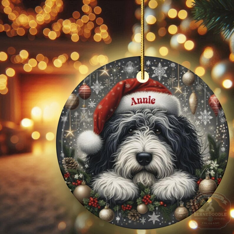 Sheepadoodle custom ornament on display with glowing lights in the background.  This 3 inch ceramic ornament is perfect for Sheepa Doodle lovers everywhere.