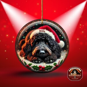 Black bernedoodle or labradoodle dog ceramic ornament show hanging with a gold string.  The ornament measures 3 inches in diameter and is a full gloss, printed on both sides.