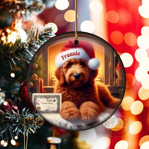 Goldendoodle Ornament - 3 inch round ceramic fully gloss Christmas Ornament hanging with a gold string against a warm background.