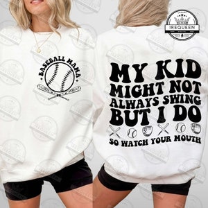 May include: White sweatshirt with black text that reads "My Kid Might Not Always Swing But I Do So Watch Your Mouth". The text is surrounded by baseball bats, baseballs, and baseball gloves. The front of the sweatshirt has a black and white baseball graphic with the text "Baseball Mama".