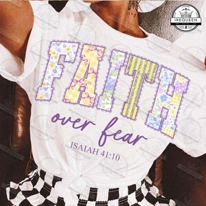 May include: White t-shirt with the word "FAITH" in large, colorful letters. The letters are decorated with floral patterns, gingham, and glitter. Below, the words "over fear" and the Bible verse Isaiah 41:10 are written in purple.