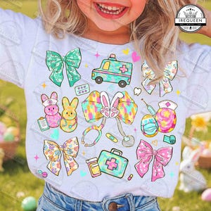 May include: White t-shirt featuring colorful illustrations of medical-themed Easter elements. The design includes bows, an ambulance, Easter eggs with masks, bunnies, and medical tools. The shirt is worn by a child.