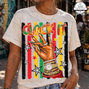 Puede incluir: Camiseta color crema con el texto "LOCK IT" en letras coloridas. El diseño presenta una mano con uñas largas y decoradas, anillos y un reloj dorado, sobre un fondo de rayas y estrellas rojas, amarillas y verdes.