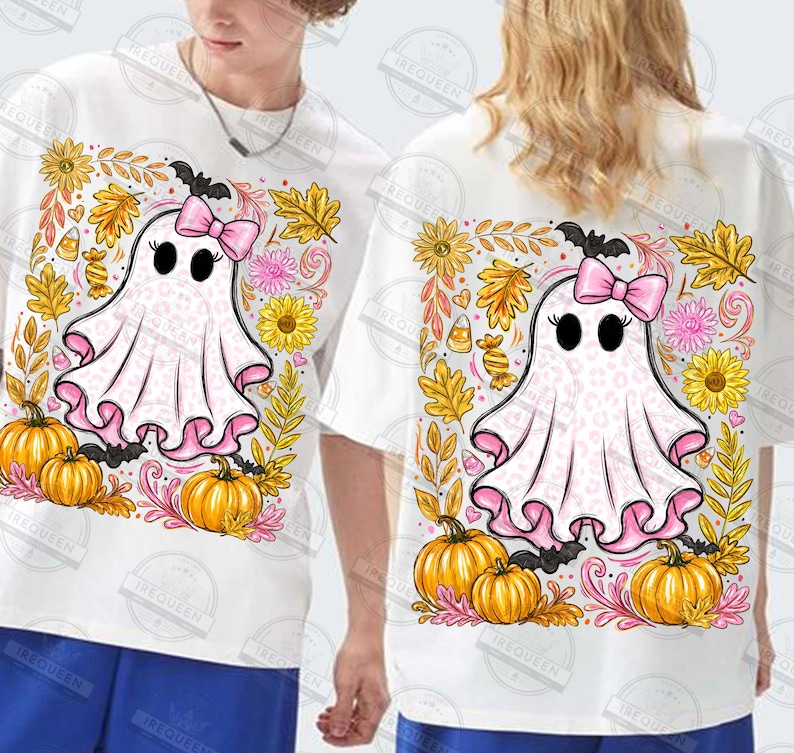 Może przedstawiać: Biały t-shirt z grafiką ducha w r&oacute;żowy wz&oacute;r panterki, noszącego r&oacute;żową kokardę. Duch jest otoczony pomarańczowymi dyniami, ż&oacute;łtymi słonecznikami, jesiennymi liśćmi i cukierkami w świątecznej, sezonowej kompozycji.