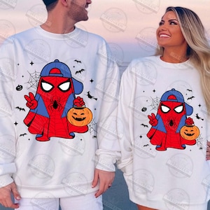 Pode incluir: Camisolas brancas com um design de fantasma do Homem-Aranha de desenho animado, com um bon&eacute; azul, um sinal de paz e uma ab&oacute;bora. O design inclui teias de aranha, morcegos e estrelas, perfeito para o Halloween. As camisolas s&atilde;o de estilo casual.