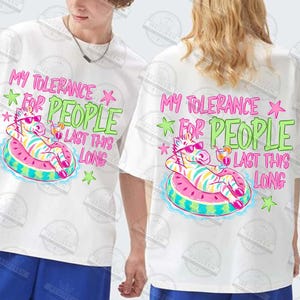 Puede incluir: Camisetas blancas con un gr&aacute;fico colorido. El gr&aacute;fico presenta una cebra con gafas de sol relaj&aacute;ndose en un flotador inflable rosa y azul, con el texto "MY TOLERANCE FOR PEOPLE LAST THIS LONG".